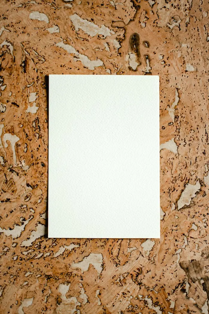 White paper positioned vertically on a textured brown surface, offering creative copyspace.
